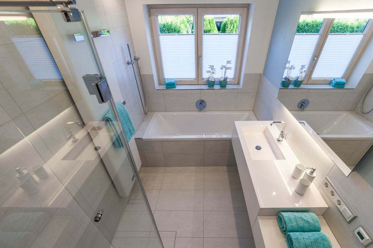 Helles, großzügiges Bad mit Badewanne, Dusche und langem Waschtisch unter Dachfenstern