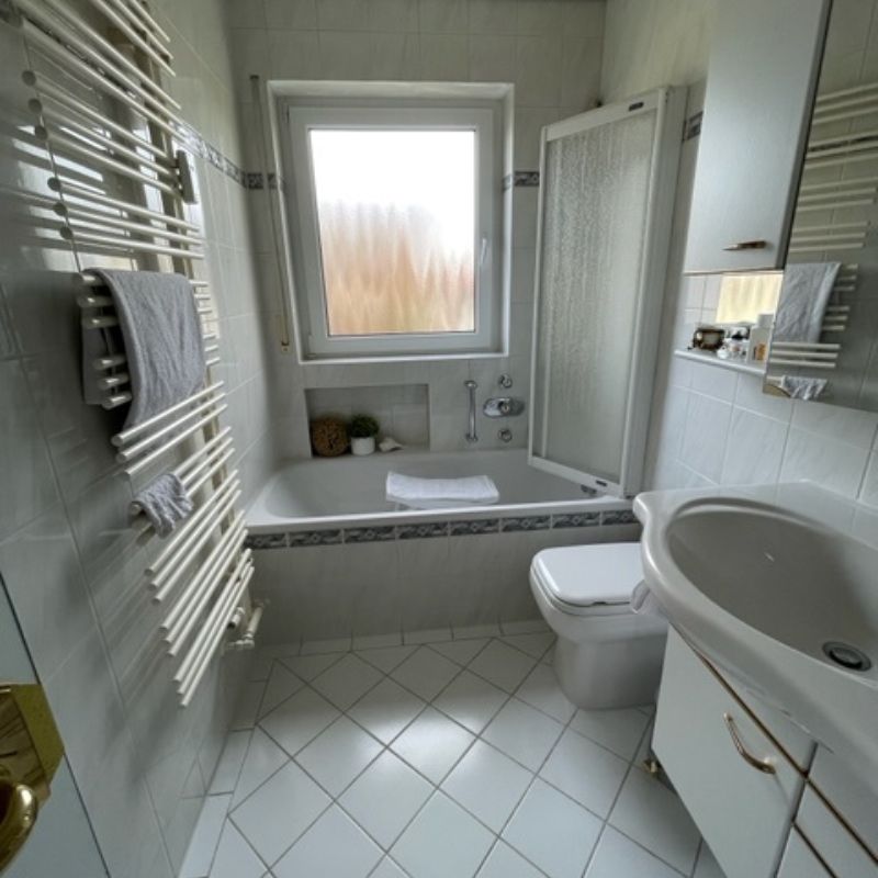 Vorher: altes Bad mit Badewanne und weißen Fliesen