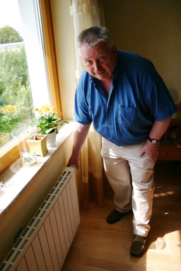 Josef Herb steht am Fenster neben einem Heizkörper aus Aluminium