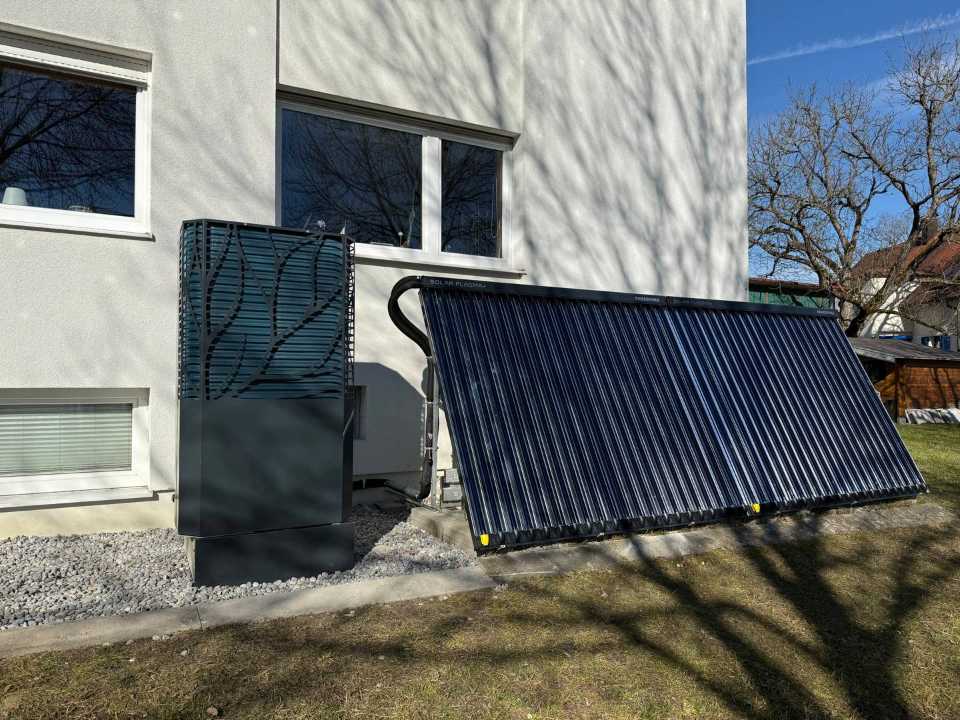 Röhrenkollektor auf einem Gestell im Garten an der Hauswand
